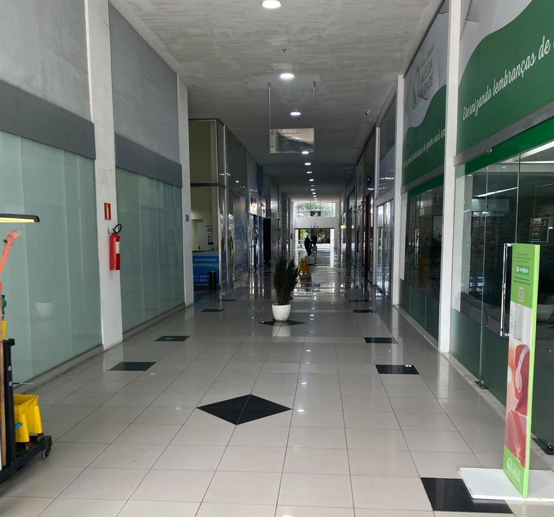 Corredor térreo do Edifício Iguatemi Business, com as lojas dos dois lados e o laboratório à esquerda